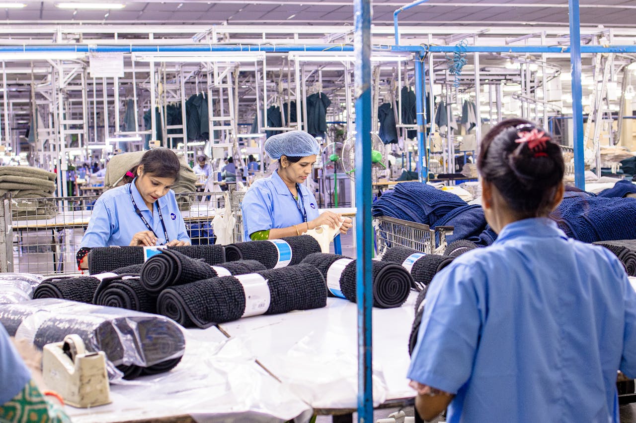 services-03 Female workers sorting fabric in a large textile factory setting, showcasing industry and teamwork.