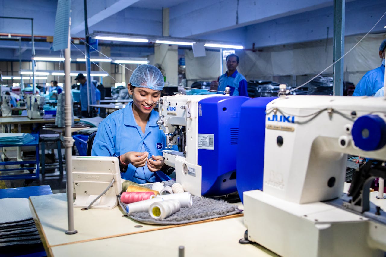services-02 Workers in a textile factory operating sewing machines, showcasing blue collar work.